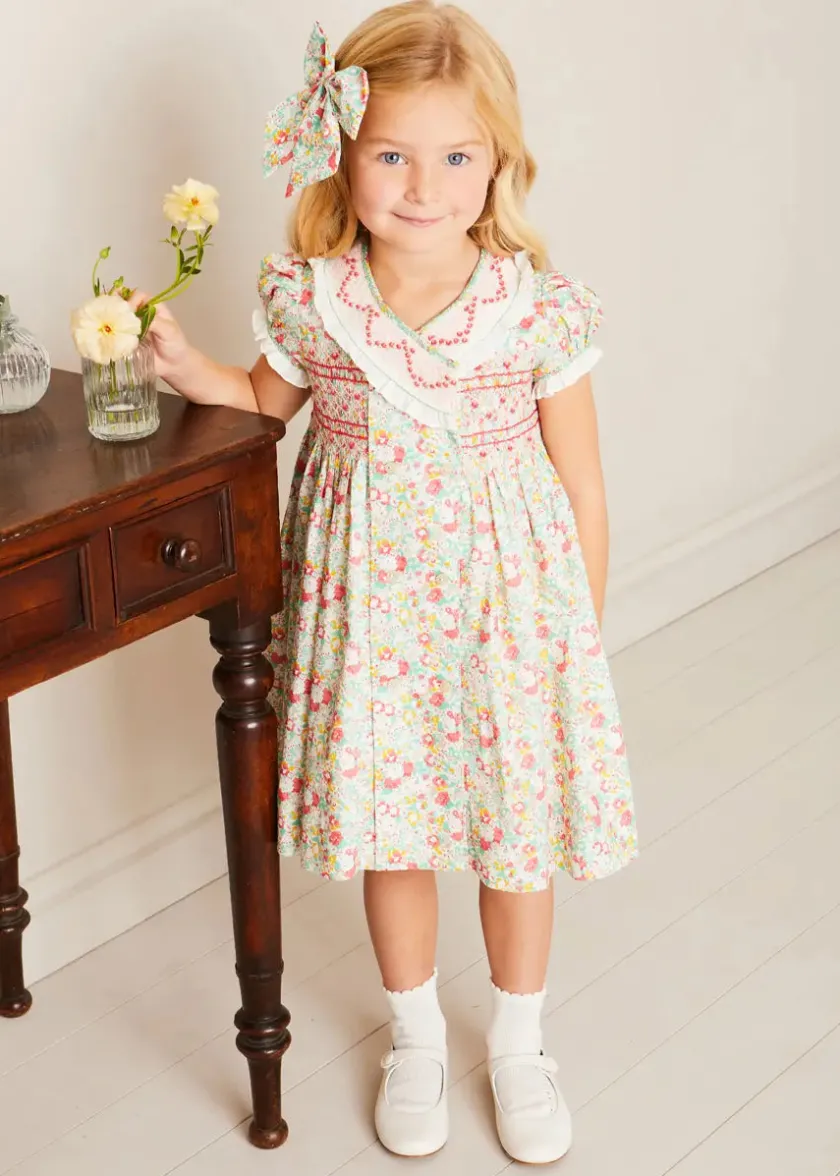 Lookbooks | Pepa London Clementine Floral Hand Smocked Double Breasted Short Sleeve Dress in Coral (12mths-10yrs) | Mary Jane Leather Baby Shoes in Ivory (20-24EU) | Clementine Floral Long Bow Hair Clip in Coral | Openwork short socks White (0mths-8yrs)