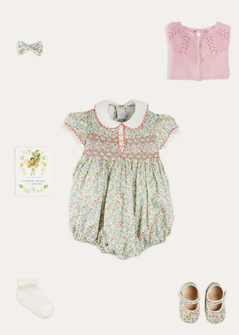 Lookbooks | Pepa London Cordelia Floral Hand-Smocked Short Sleeve Romper in Pink Made with Liberty Fabric (3m-2yrs) | Openwork Cotton Knitted Bonnet in Pink (S-L) | Openwork Cotton Cardigan in Pink (6mths-10yrs) | Cordelia Liberty Floral Mary Jane Pram Shoes in Pink (17-20EU) | Flower Fairies of the Spring Book in White | Cordelia Floral Small Bow Clip in Pink Made with Liberty Fabric | Openwork short socks White (0mths-8yrs)