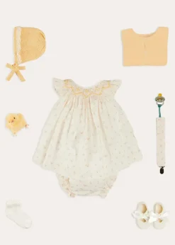 Lookbooks | Pepa London Esme Floral Hand Smocked Sleeveless Dress With Bloomers in White (1-12mths) | Openwork Detail Cotton Baby Cardigan in Tangerine (1-12mths) | Lace Detail Knitted Bonnet in Tangerine (1-12mths) | Celebration Ribbon Detail Mary Jane Pram Shoes in Beige (17-20EU) | Esme Floral Dummy Clip in White | Openwork short socks White (0mths-8yrs) | Chick Toy in Yellow