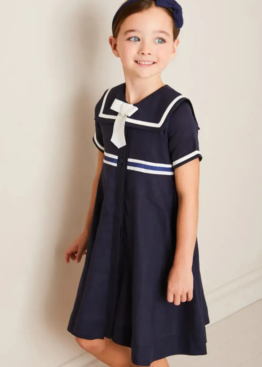 Lookbooks | Pepa London Mariner Collar Bow Detail Short Sleeve Dress in Navy (4-12yrs) | Plain Cardigan in Navy (6mths-10yrs) | Girls Ivory Leather Mary Jane Shoes (20-34EU) | Navy Linen Big Bow Hairband | Cotton Short Socks Cream (0mths-10yrs)