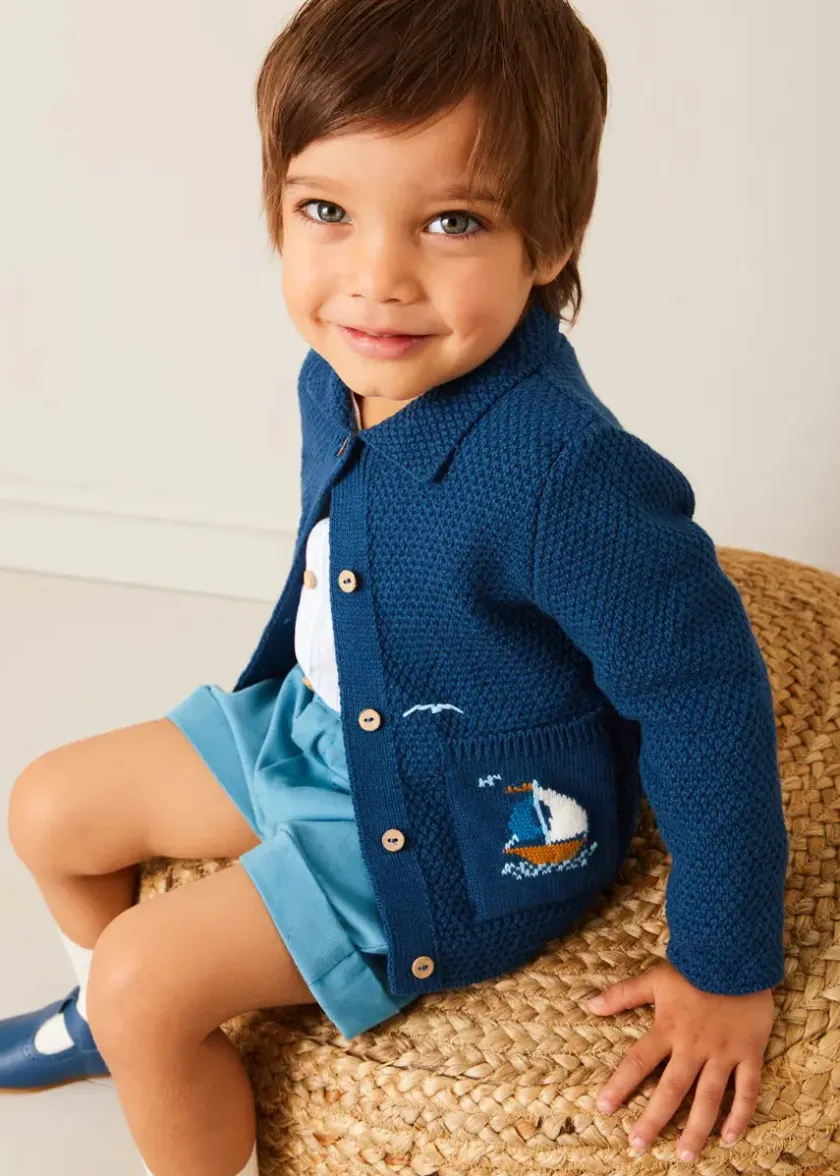 Lookbooks | Pepa London Nautical Boat Embroidery Polo Collar Cardigan in Blue (12mths-6yrs) | Chesham Striped Mao Collar Long Sleeve Shirt in Red (3-10yrs) | Plain Elasticated Shorts in Blue (12mths-4yrs) | T-Bar Baby Shoes in Blue (20-26EU) | Ribbed Short Socks in Beige (0mths-10yrs)