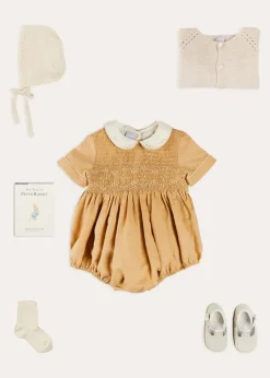 Lookbooks | Pepa London Peter Pan Collar Hand Smocked Short Sleeve Romper in Camel (6mths-2yrs) | Plain Cardigan in Cream (6mths-10yrs) | Openwork Knitted Bonnet in Beige(S-L) | T-Bar Leather Pram Shoes in Ivory (17-20EU) | Cotton Short Socks Cream (0mths-10yrs)